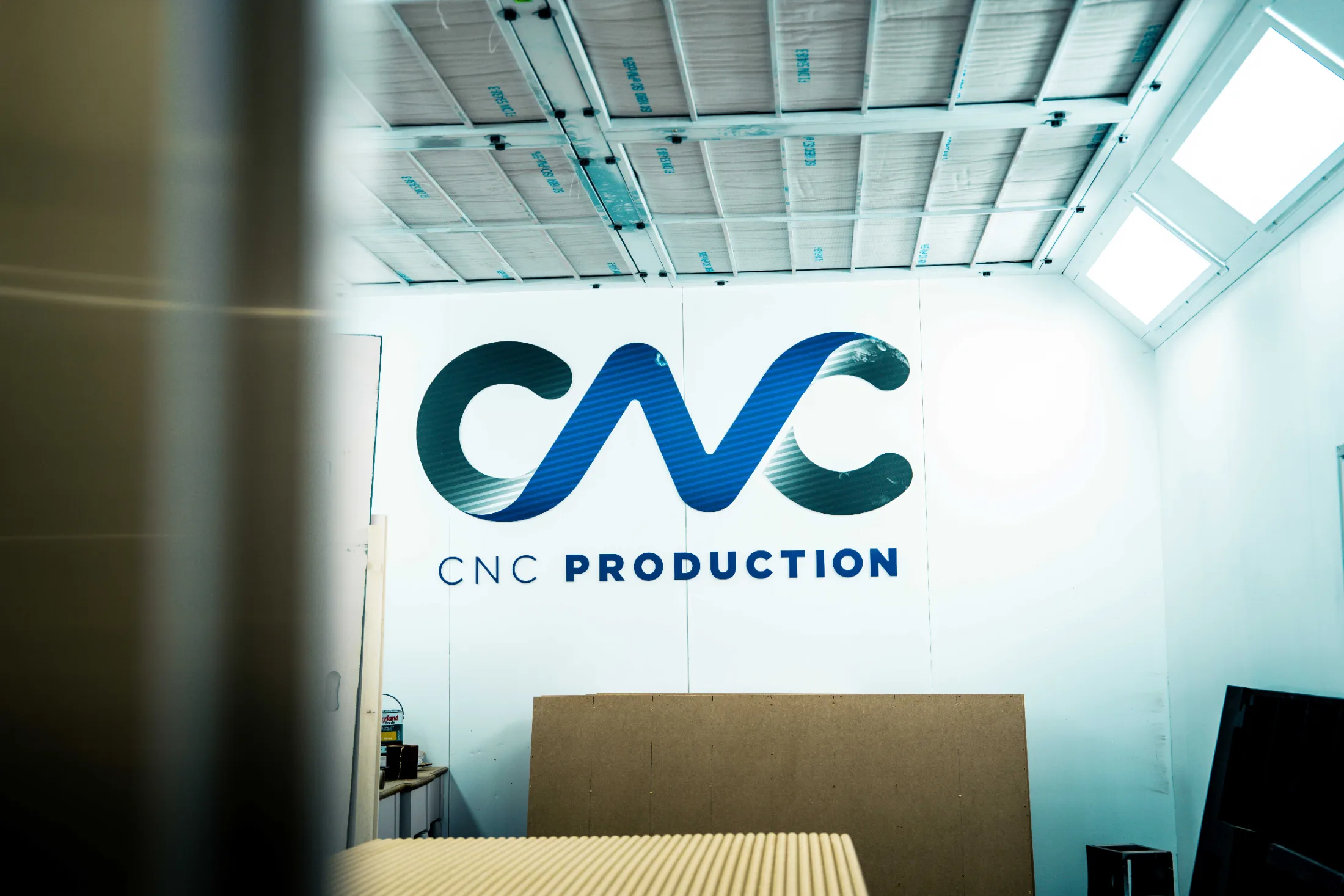 Large-format printed CNC Production logo panel in the workshop