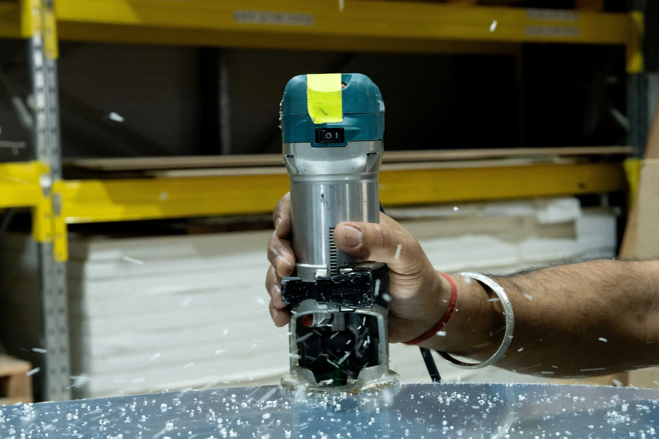 Trimming a cut acrylic panel with a hand router at CNC Production