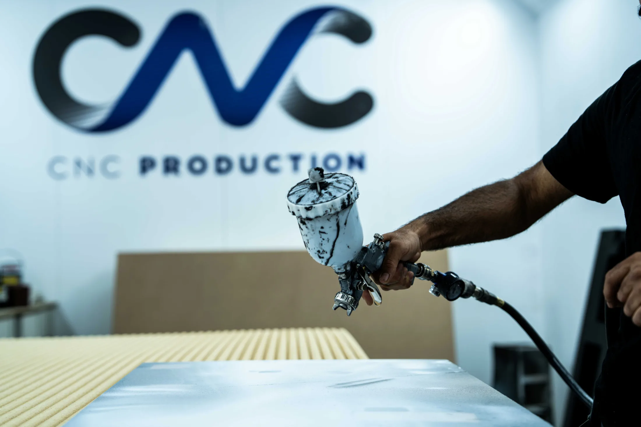 Spray gun laying a colour-matched finish onto a panel in the spray booth